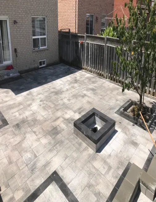 Patio en pavé uni avec foyer extérieur